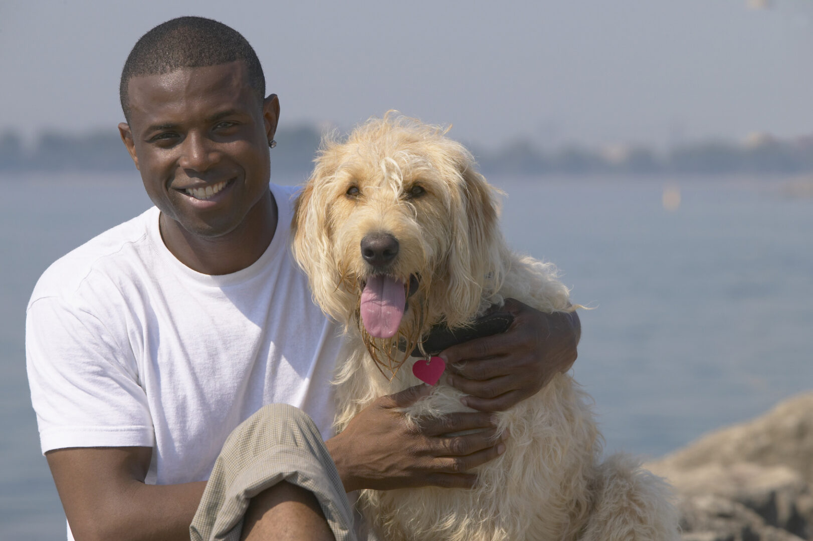 A man wearing a white shirt and a dog