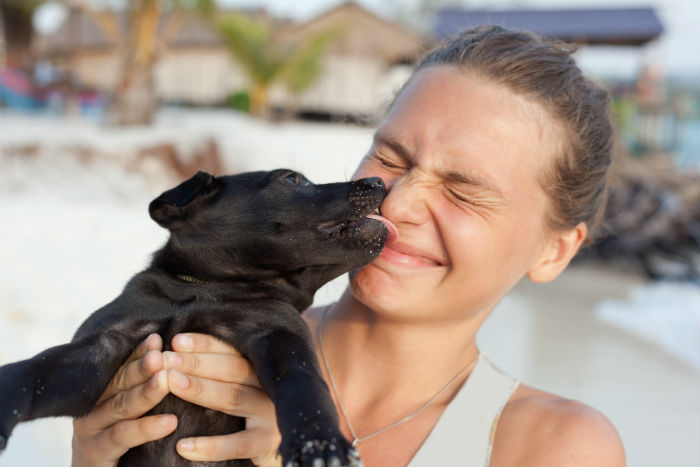 A woman and a black puppy